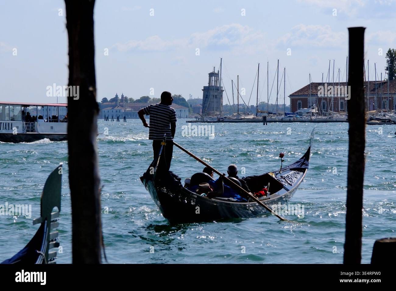 Venezia, Italia - 28 settembre 2025: Gondoliere su gondola che trasporta turisti nella laguna di Venezia Foto Stock