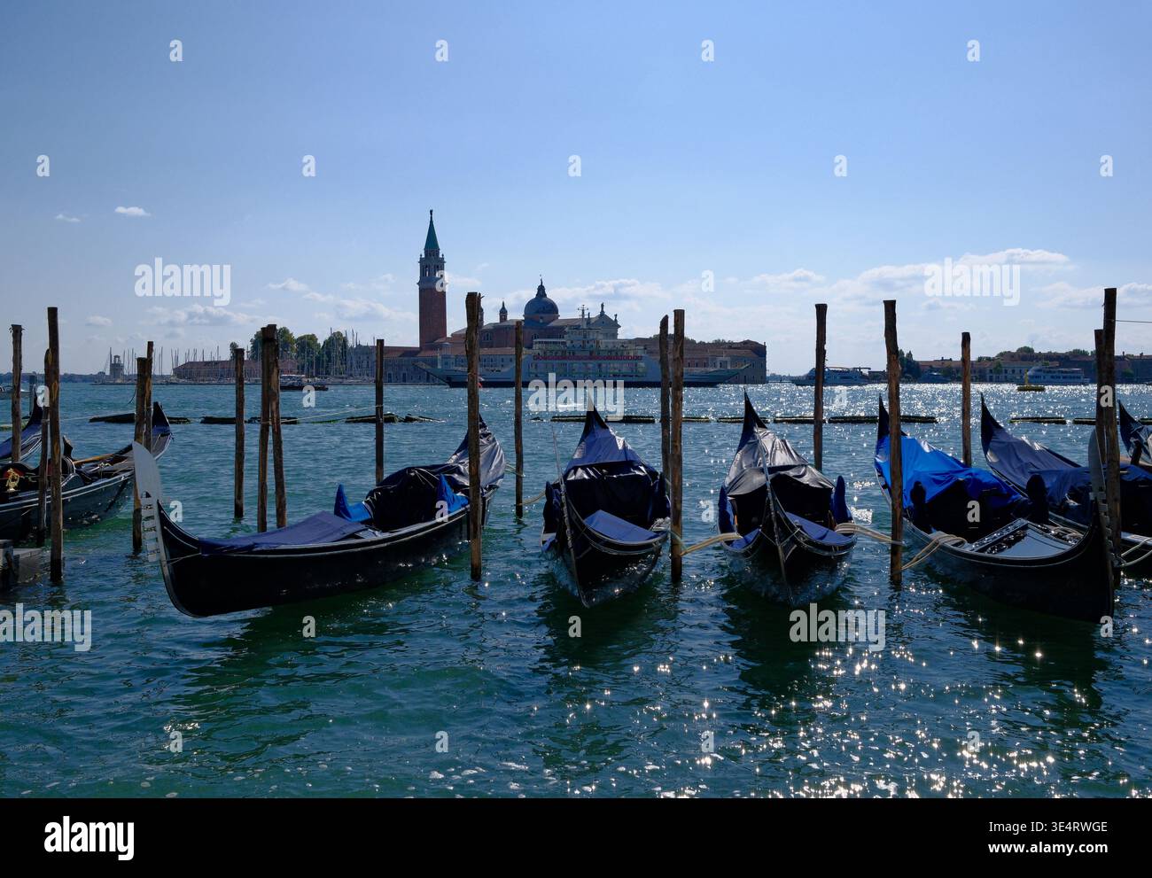 Gondole ormeggiate sull'acqua della laguna color smeraldo a Venezia, Italia Foto Stock