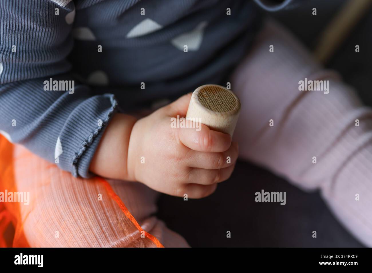 Giocattoli musicali per bambini in mano, sviluppo precoce, gioco tattile e concetto di crescita cognitiva. Foto Stock