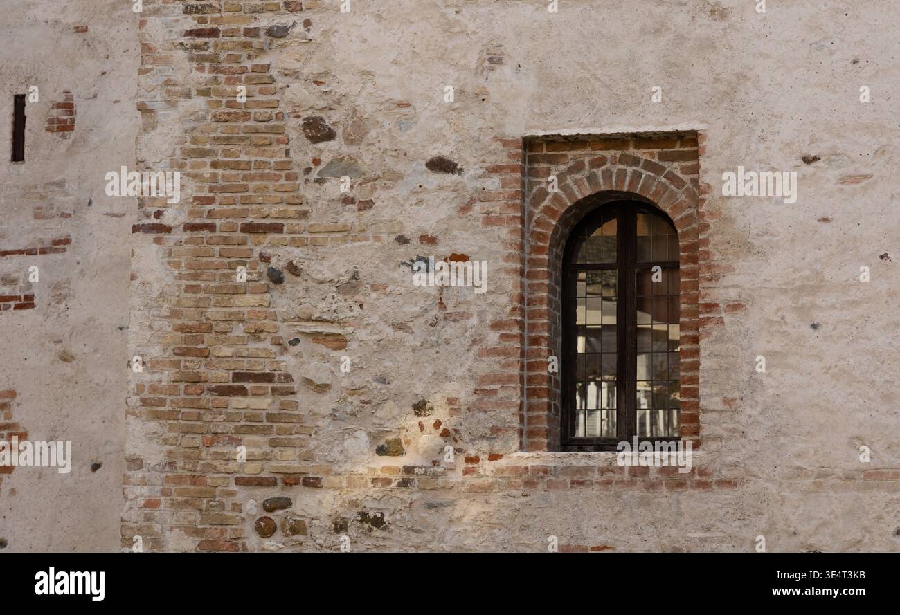 Vecchie pareti in mattoni con finestre ad arco, dettagli architettonici medievali e sfondo testurizzato Foto Stock