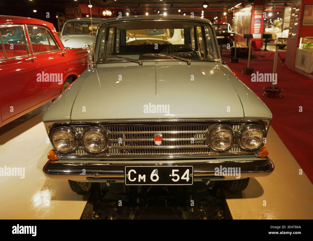 Una scintillante Moskvich 408 Kombi con due fari rotondi è fotografata dalla parte anteriore, illuminata per evidenziare la sua finitura lucida e il classico stile sovietico. Foto Stock