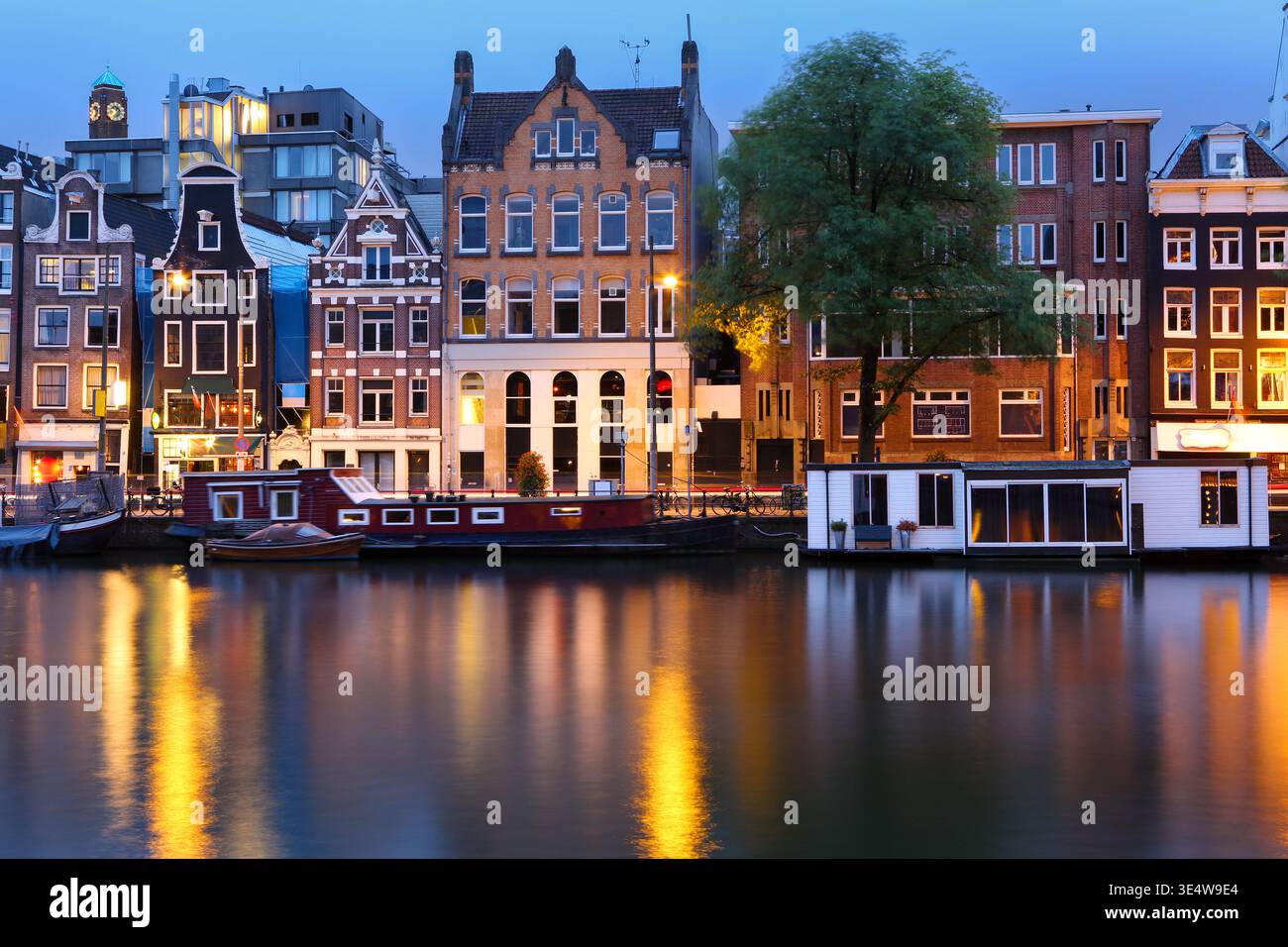Le tradizionali case olandesi confinano con il fiume Amstel ad Amsterdam, nei Paesi Bassi Foto Stock