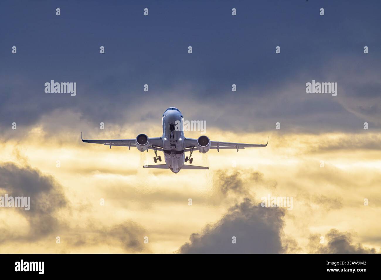 Aeroporto di Stoccarda con l'aereo in decollo. Eurowings Airbus A320 di fronte a nuvole buie, illuminati di sera. Stoccarda, Baden-Wuerttemberg, tedesco Foto Stock
