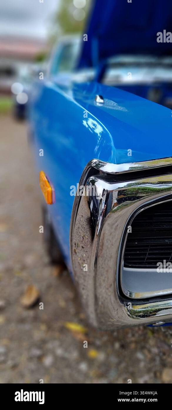 Primo piano di una classica auto americana con paraurti cromato e carrozzeria blu, parte di una serie di veicoli d'epoca con dettagli sul motore e sugli esterni. Foto Stock