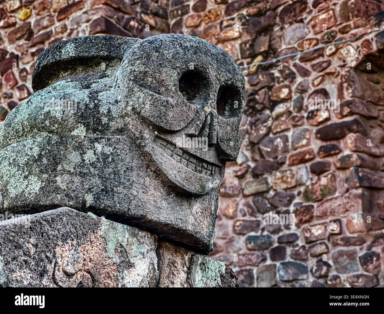 La scultura in pietra di uno scheletro in un cimitero di Cusco, in Perù, sembra la testa della morte. Foto Stock