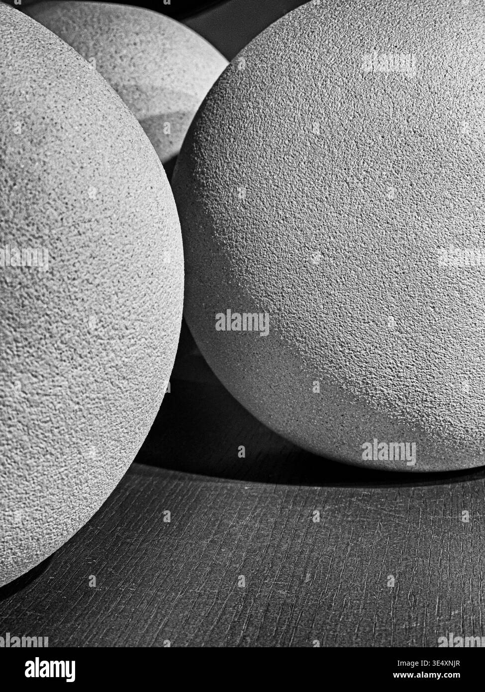 Vista astratta di luci e ombre che cadono su diverse palle di argilla su uno scaffale. In bianco e nero. Foto Stock