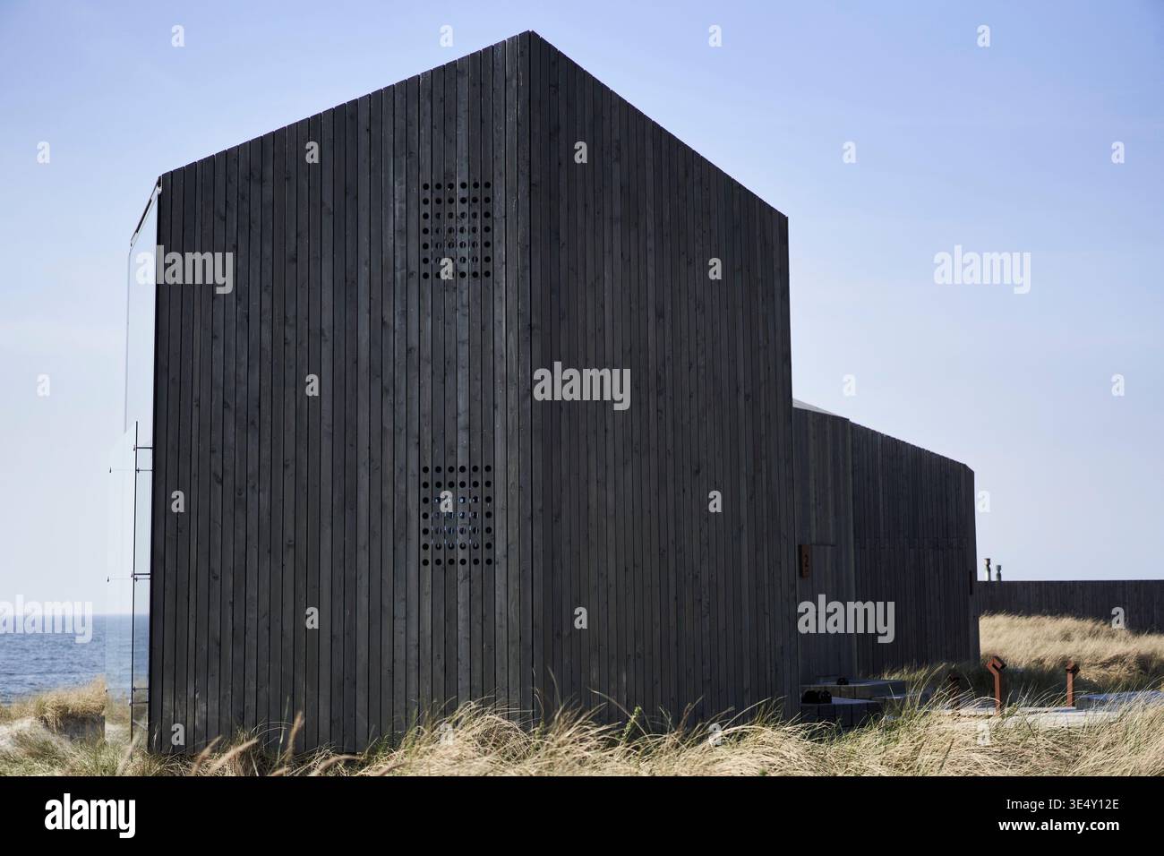 Ripari costieri in legno che si affacciano sul mare con dune e cielo mutato per la fotografia editoriale Foto Stock