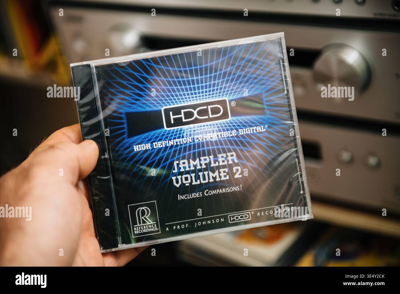 Parigi, Francia - 09 marzo 2026: Primo piano POV di Hand Holding HDCD Sampler volume 2 album davanti al sistema audio Hi-fi che mette in evidenza lo scavo ad alta definizione Foto Stock