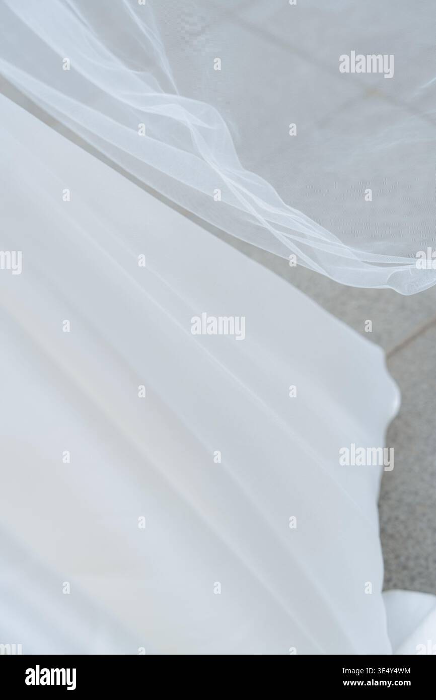 Morbido velo da sposa e tessuto da vestire in movimento. Texture nuziale minimal ed elegante, estetica leggera ed ariosa. Perfetto per la moda e il matrimonio Foto Stock