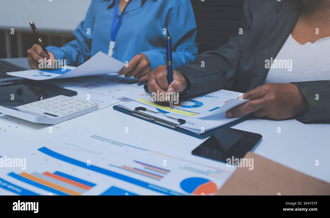 Il team revisore e contabile che lavora in ufficio analizza i dati finanziari e i record contabili con la calcolatrice. La società di contabilità fornisce servizi finanziari e servizi finanziari Foto Stock