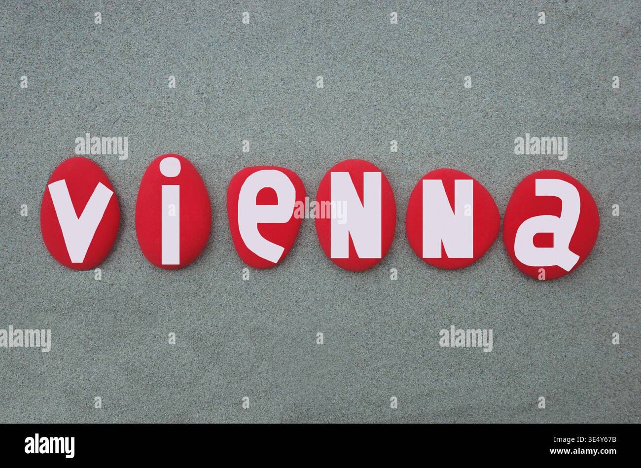 Vienna, capitale dell'Austria. Souvenir creativo composto con lettere di pietra dipinte a mano di colore rosso su sabbia verde per un logo unico, poster Foto Stock