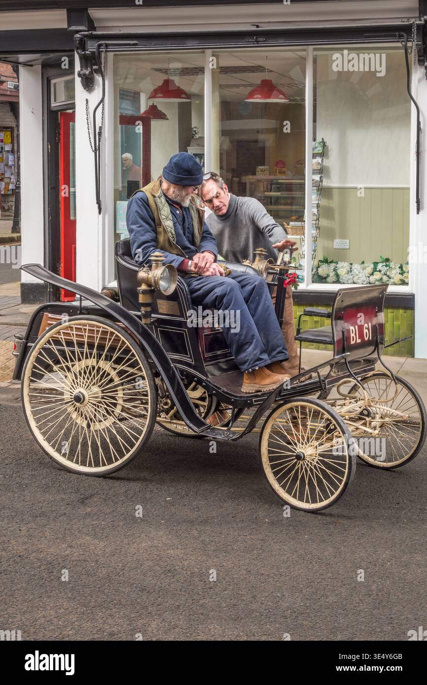 Il proprietario Ben Collings (rt) dimostra il suo Benz velo restaurato del 1898 a un passeggero. L'auto è spesso presente nella famosa corsa di auto Veteran Car Run di Londra-Brighton Foto Stock