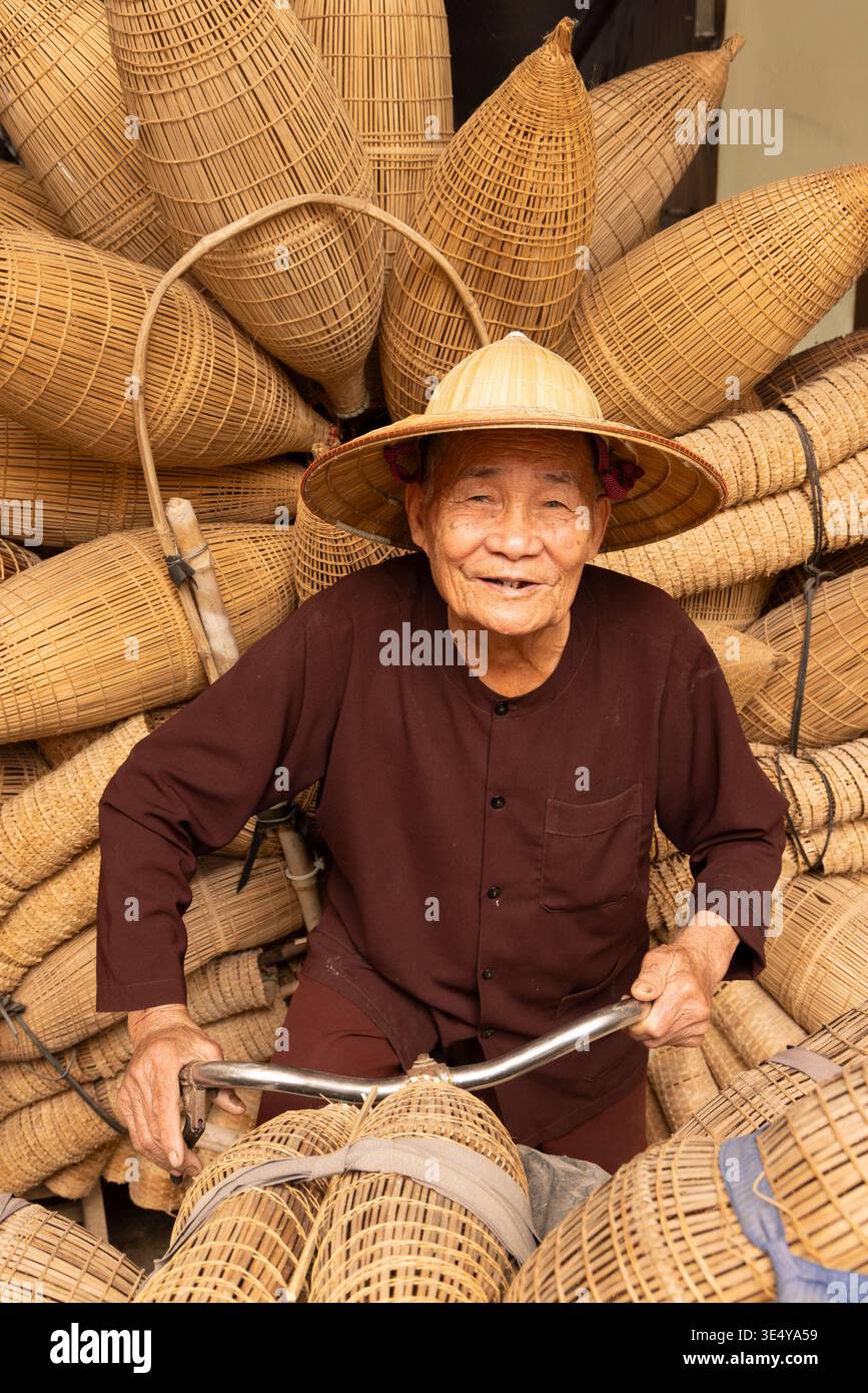 Artigiano locale che trasporta trappole da pesca di bambù fatte a mano, villaggio di Thu Sy, Hanoi, Vietnam, Asia sudorientale Foto Stock