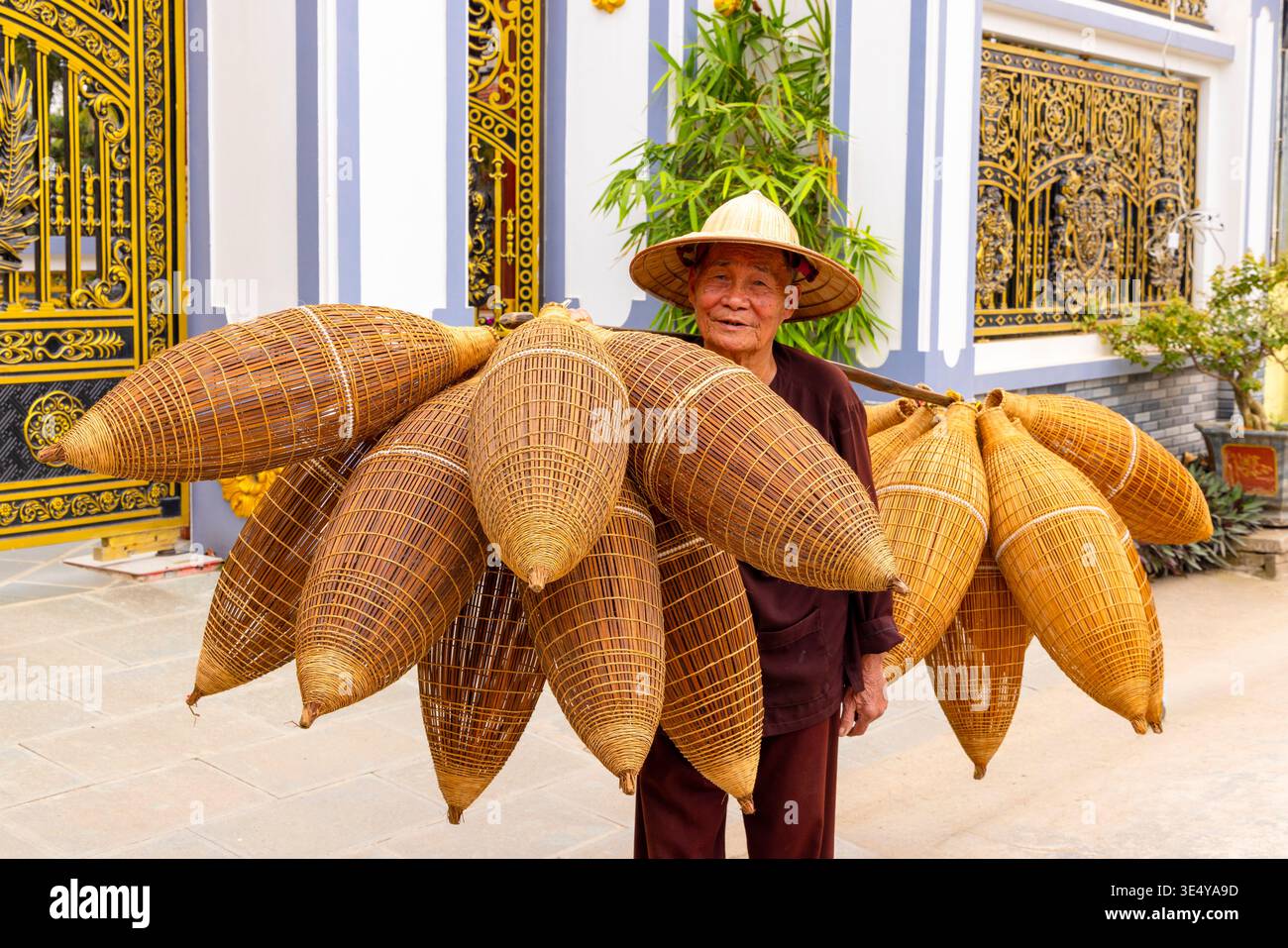 Artigiano locale che trasporta trappole da pesca di bambù fatte a mano, villaggio di Thu Sy, Hanoi, Vietnam, Asia sudorientale Foto Stock