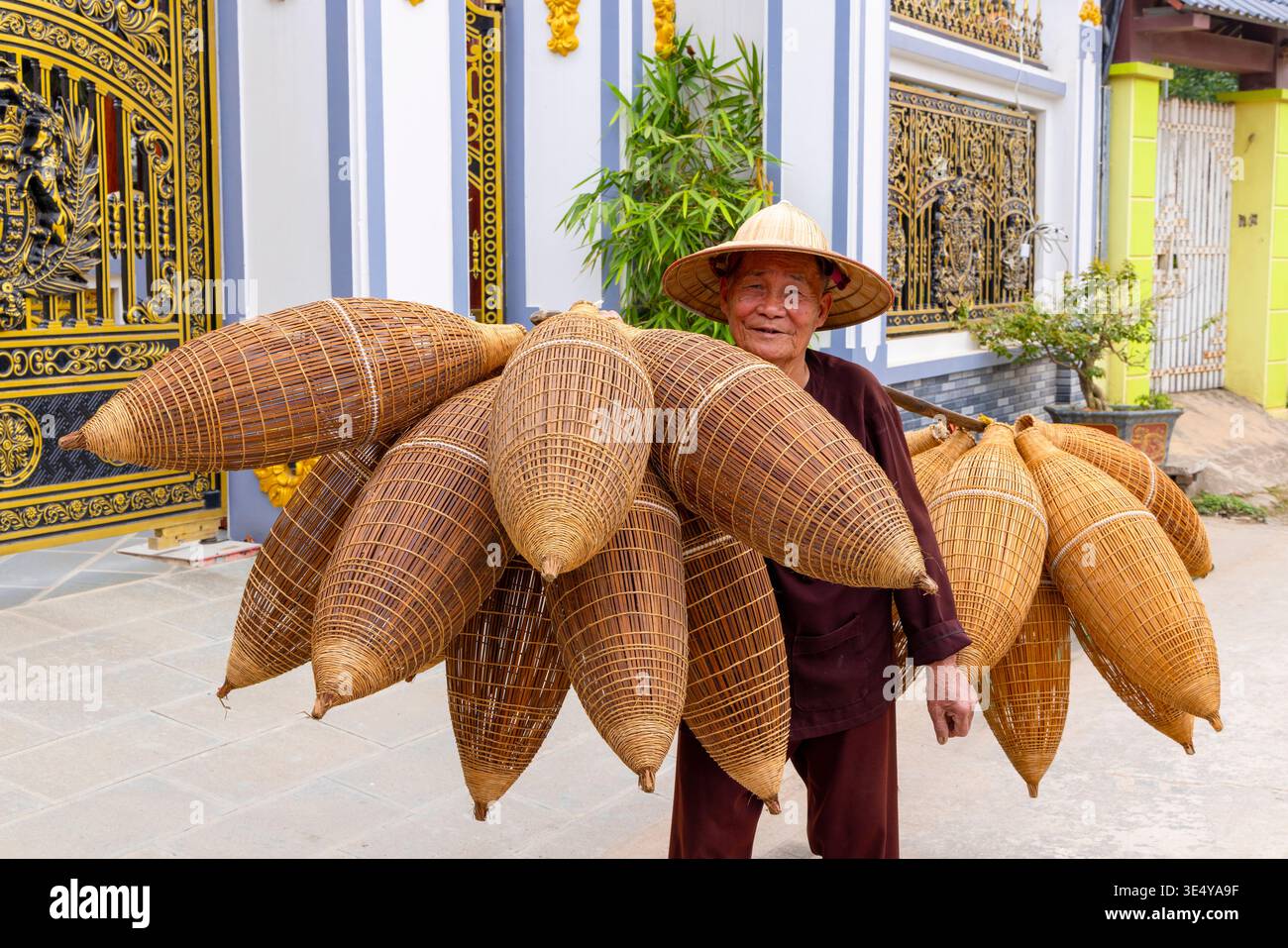 Artigiano locale che trasporta trappole da pesca di bambù fatte a mano, villaggio di Thu Sy, Hanoi, Vietnam, Asia sudorientale Foto Stock
