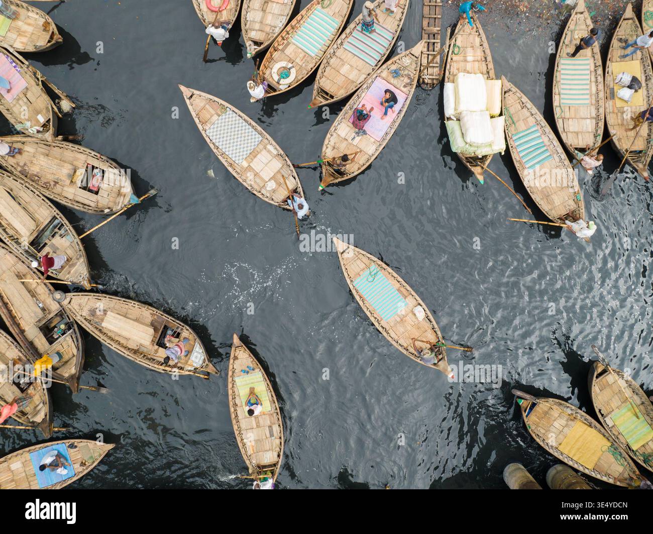 Vista aerea di numerose piccole barche raggruppate vicino sull'acqua, alcune trasportano merci e persone, creando un vivace arazzo della vita fluviale Foto Stock