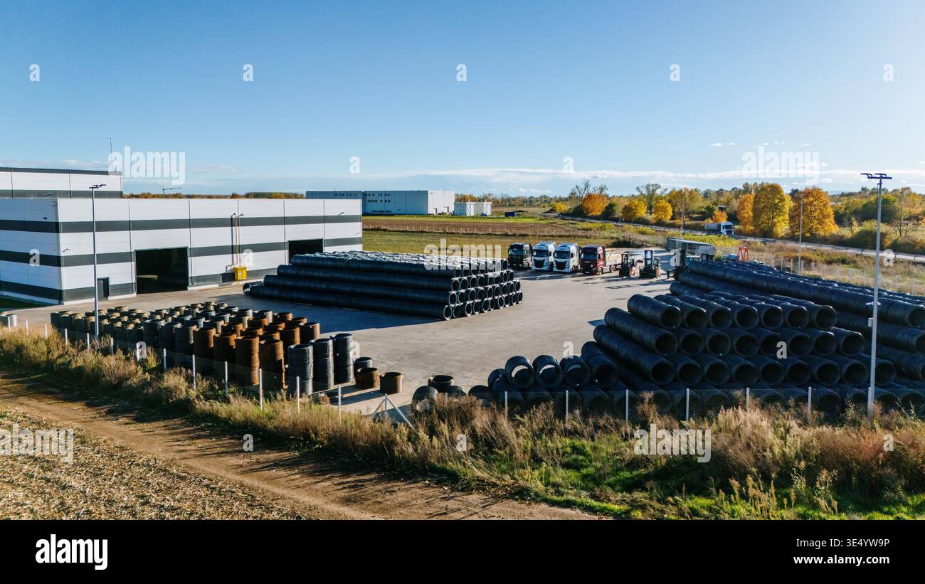 Vista aerea di canne scure in contrasto con gli edifici luminosi, con camion allineati in lontananza, sotto un cielo limpido, Sremska Mitrovica, Vojvodina Foto Stock