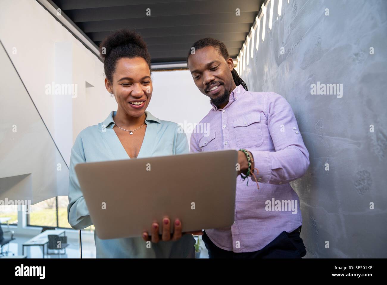 Collaborazione tra team e trasformazione digitale con colleghi che condividono idee in un notebook in ufficio Foto Stock