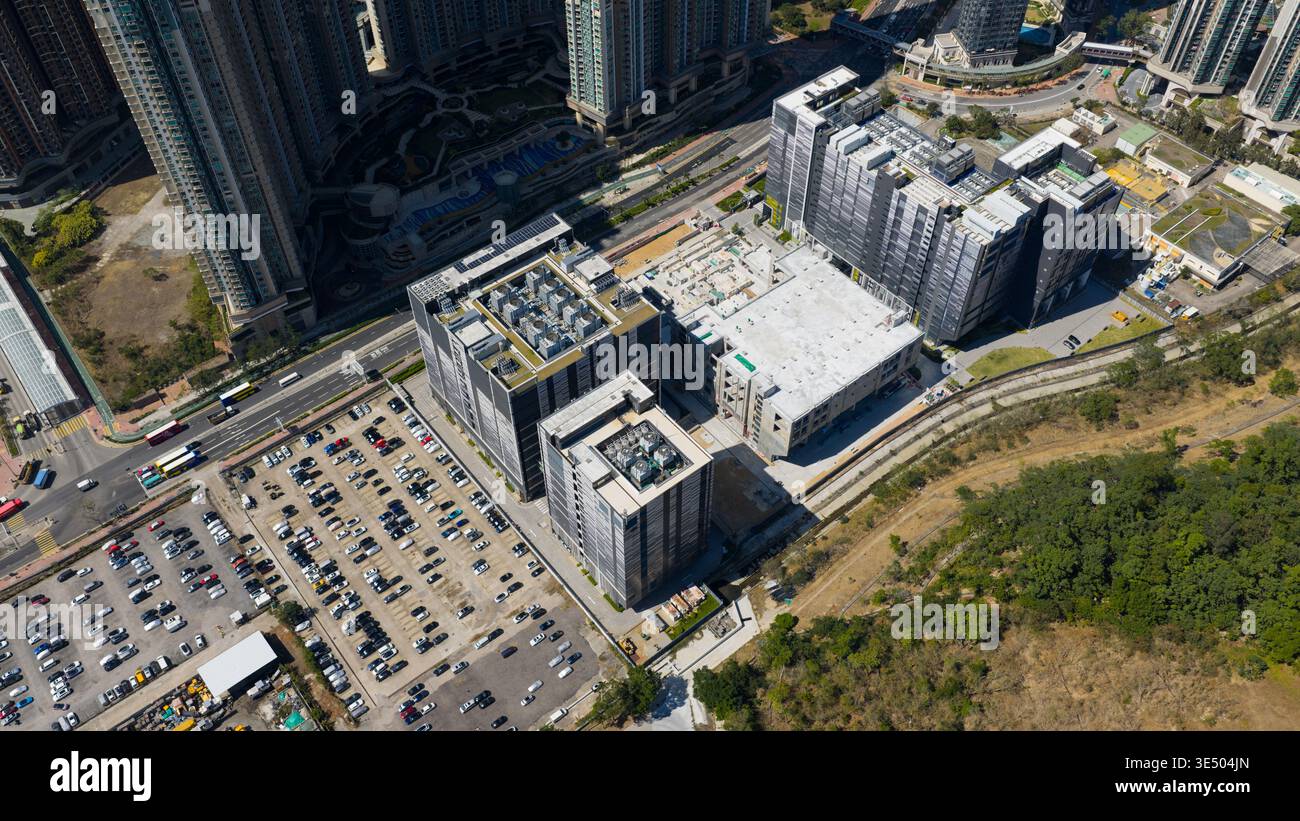 Vista aerea del complesso del data center con moderni edifici industriali, ampio parcheggio e grattacieli residenziali circostanti a Tseung Kwan o, New Foto Stock
