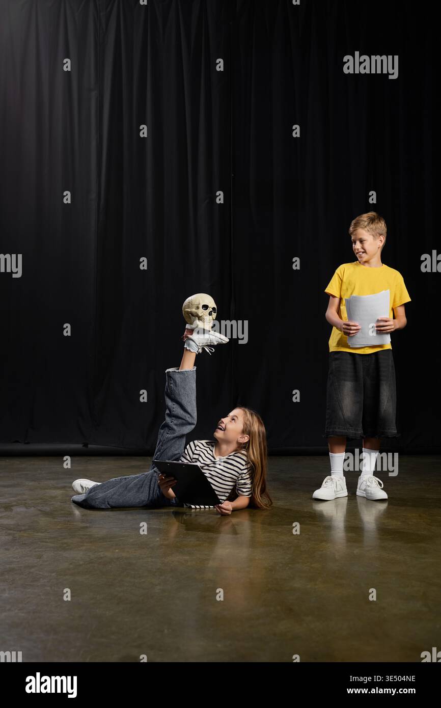 Due bambini provano un gioco fantasioso, mettendo in mostra il loro talento con un supporto per il cranio. Foto Stock