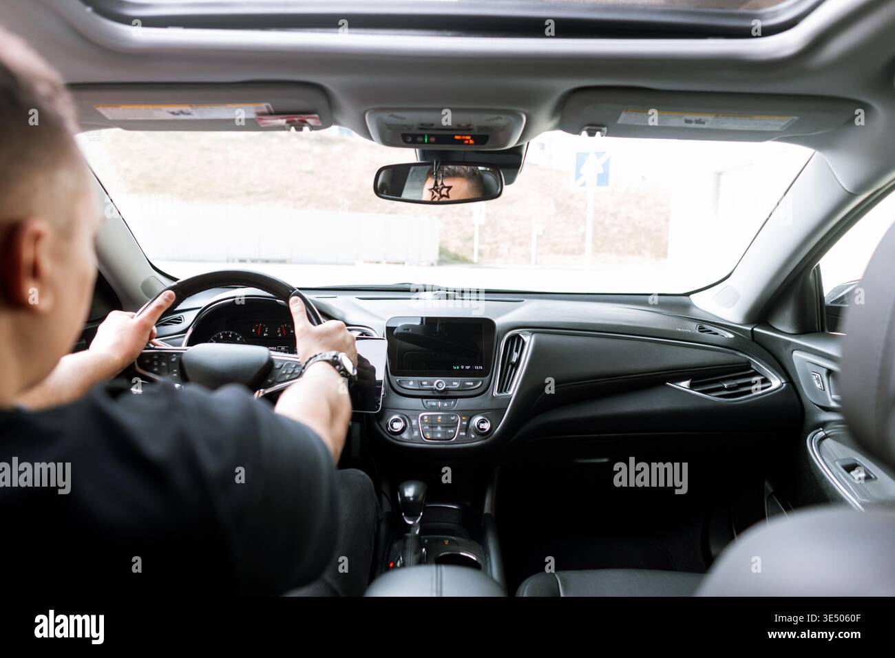 l'uomo siede in macchina ed è pronto ad andare. Comprare e noleggiare un'auto. Conducente Foto Stock