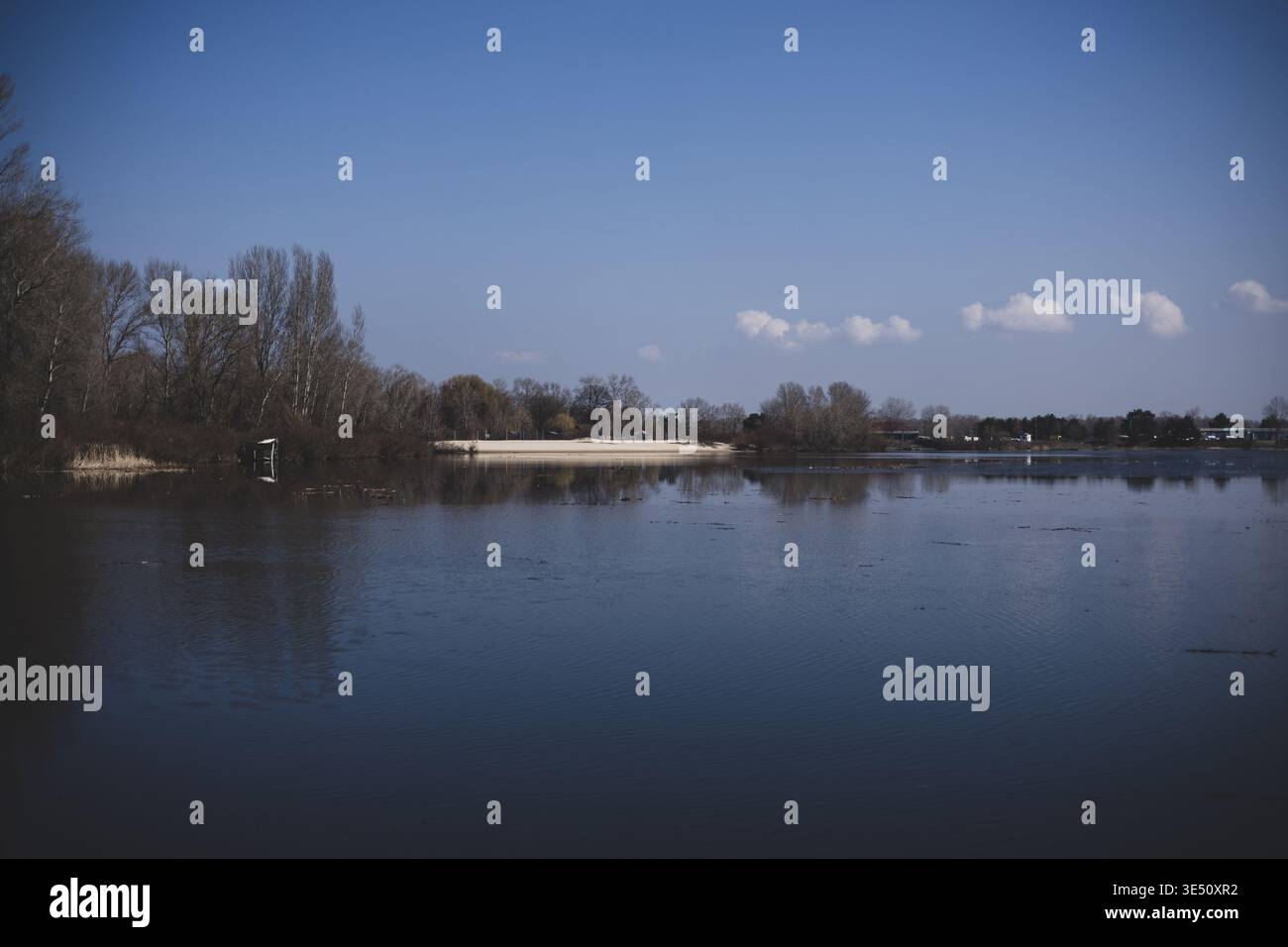 Suggestivo paesaggio fluviale con un cielo ammoso, scenografico sfondo naturale Foto Stock
