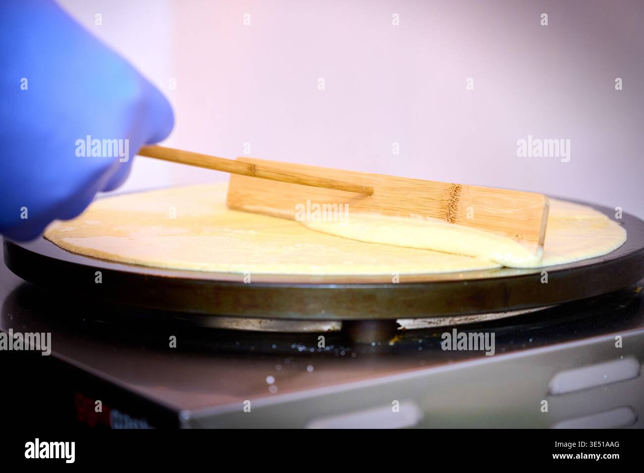 Preparare pancake rumeni con cioccolato sulla griglia elettrica Foto Stock