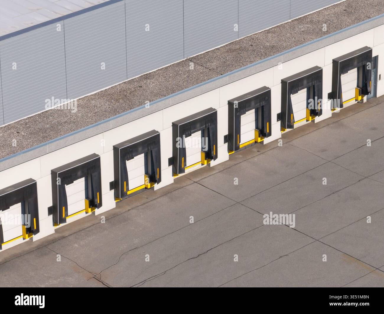 La vista aerea mostra un centro logistico con più edifici di magazzino e banchine di carico in funzione per il movimento delle merci. Foto Stock