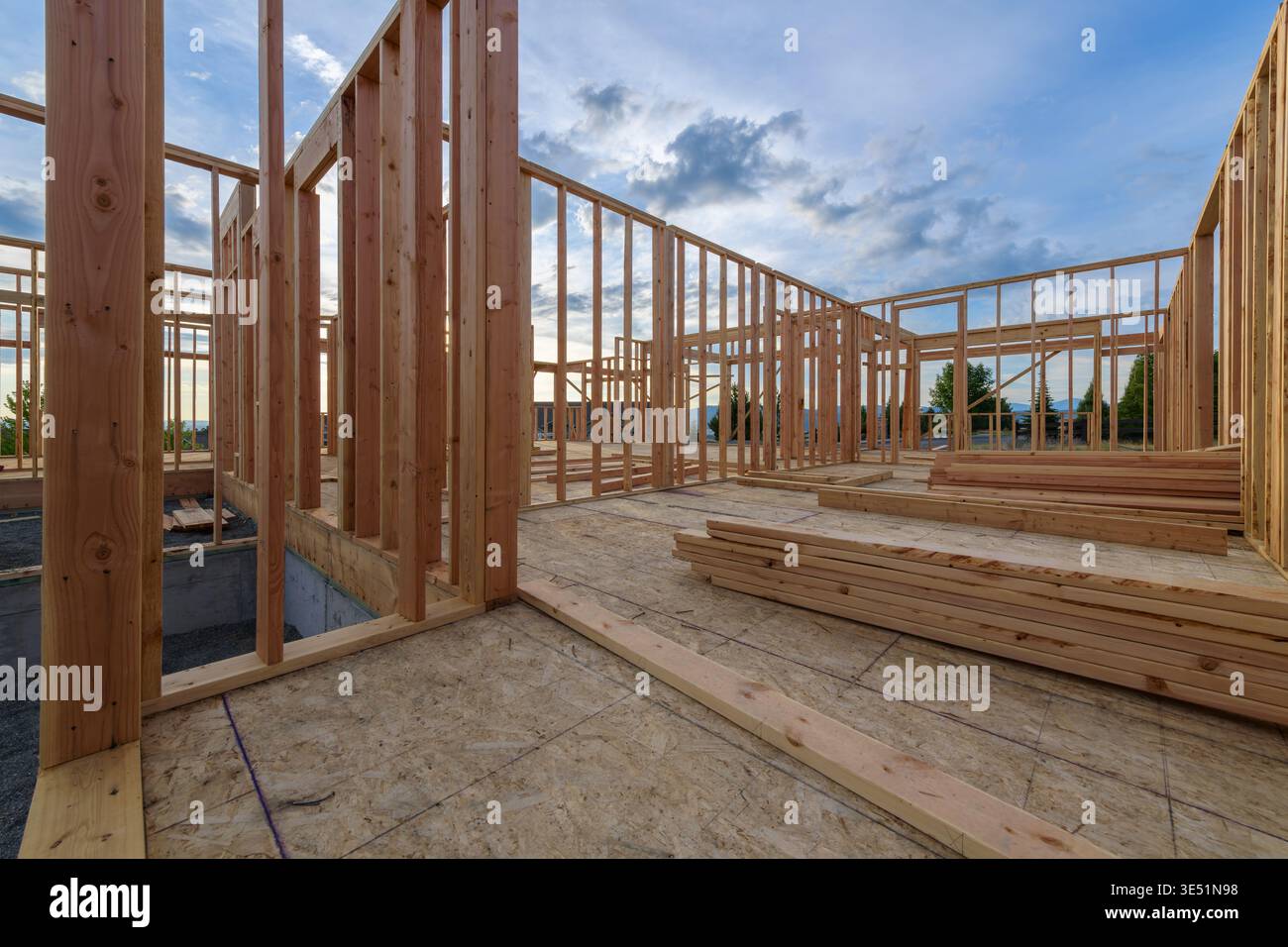 Una nuova casa nella frangente della costruzione residenziale con pareti costruite e una base in cemento per il supporto strutturale. Foto Stock