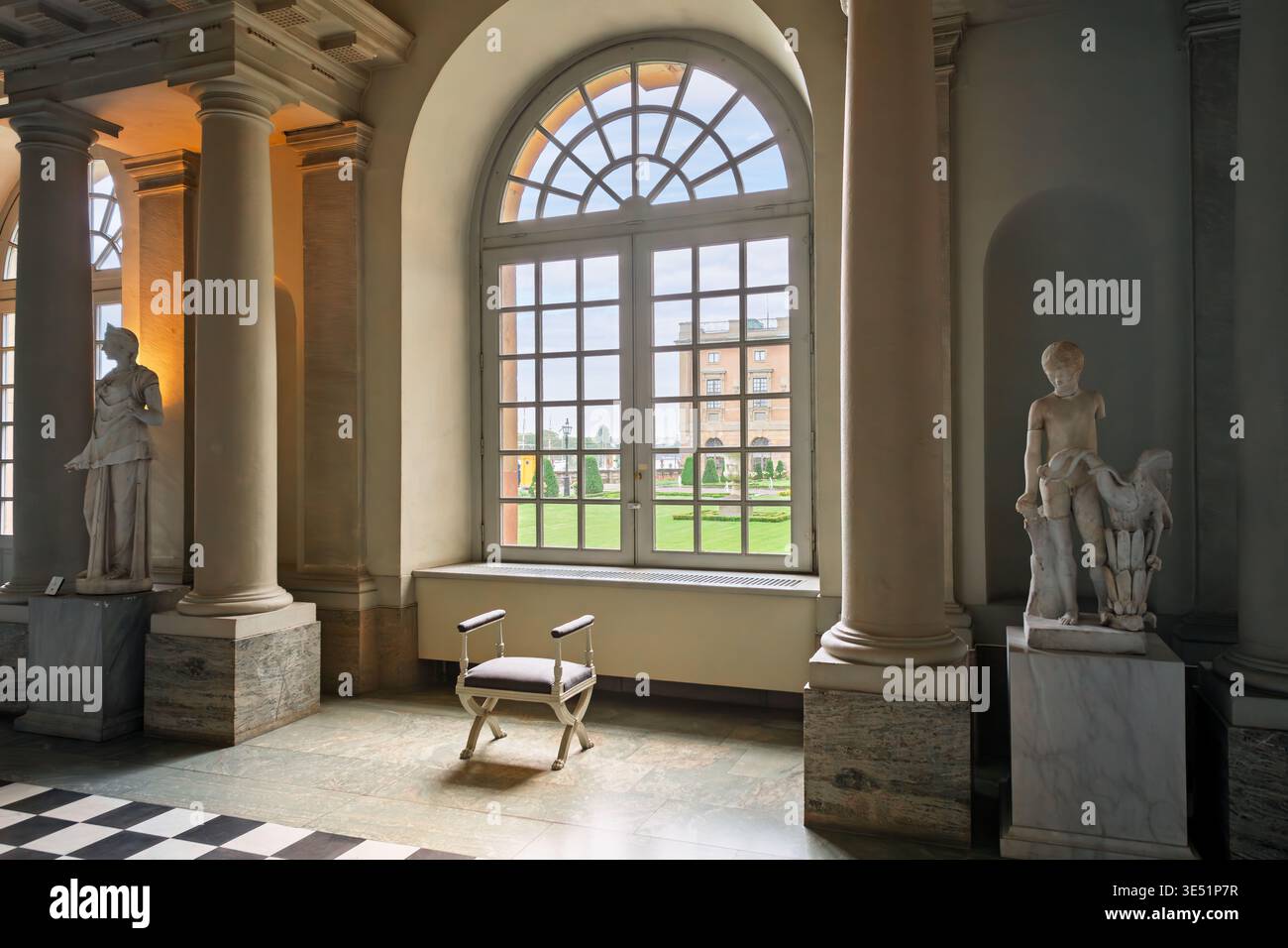 Una sedia siede di fronte a una finestra ad arco con vista sul Logårdengarden del Palazzo reale, dall'interno della sala delle antichità, Stoccolma Svezia Foto Stock