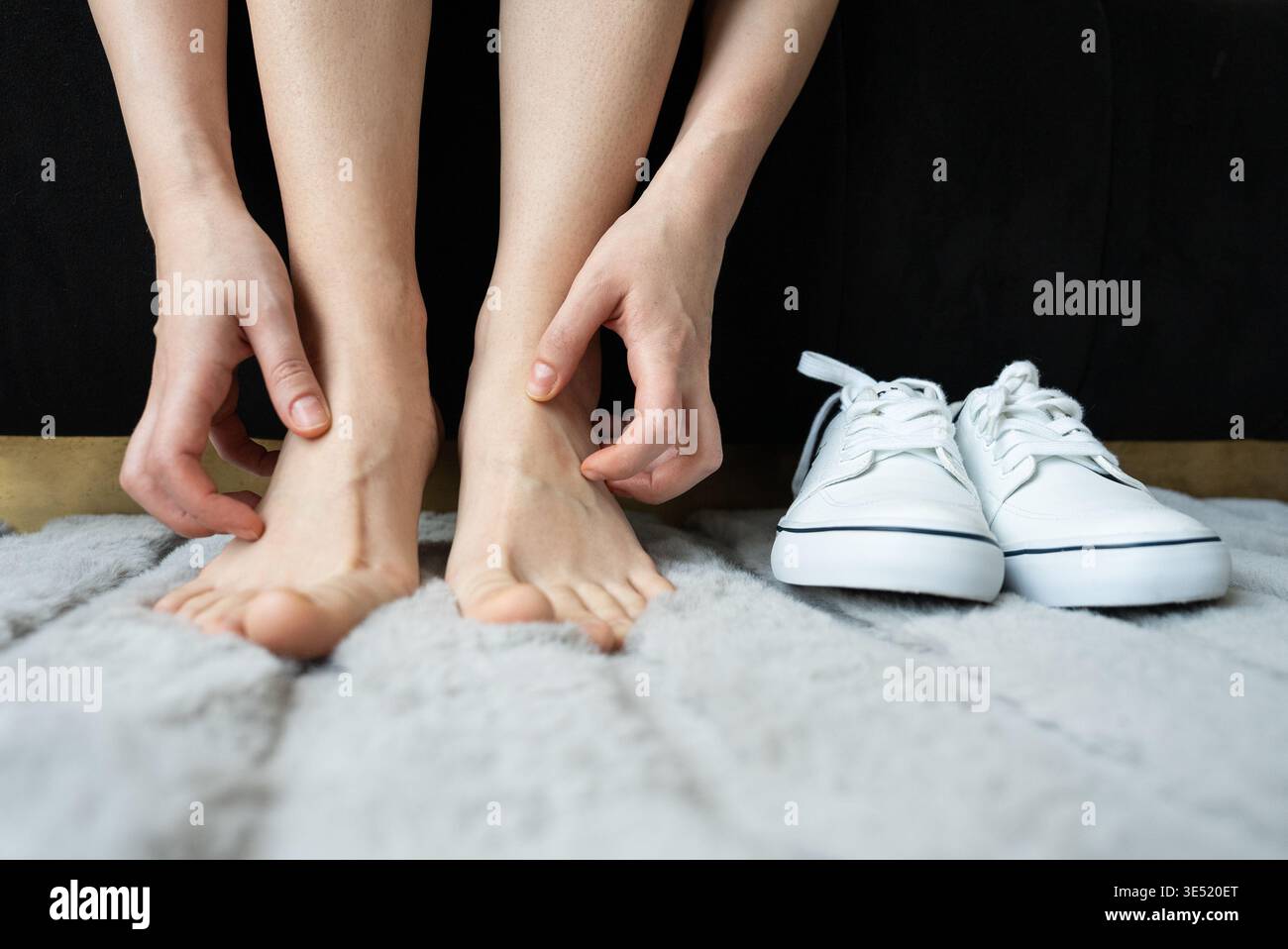 Donna che si gratta il piede dopo essersi tolta le scarpe. Concetto di prurito, disagio, igiene dei piedi e irritazione della pelle. Foto di alta qualità Foto Stock