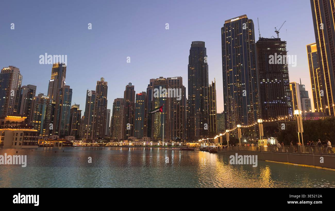 Vista panoramica notturna dello spettacolo della fontana di Dubai con il Burj Khalifa illuminato e lo skyline del centro di Dubai che si riflette nel lago, Emirati Arabi Uniti Foto Stock