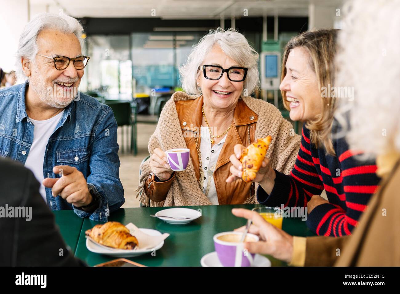 Gli amici anziani si godevano la colazione e il caffè ridevano insieme Foto Stock