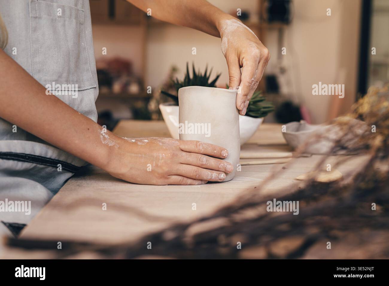 Mani di una donna potter che fa una tazza di argilla. Artigiano che modellano l'argilla con le mani Foto Stock