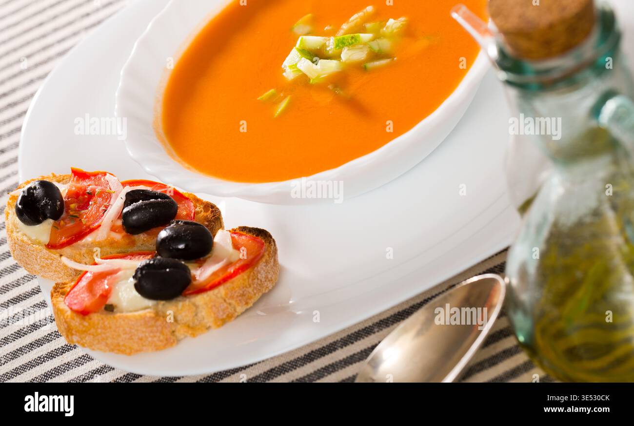 Tradizionale gazpacho per zuppa fredda servito con panini caldi Foto Stock
