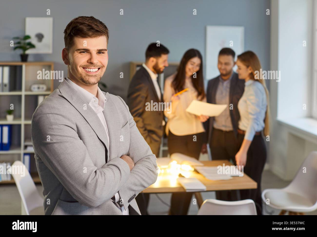 Ritratto di un uomo d'affari esperto impiegato in ufficio vestito con tuta formale, in piedi in ufficio Foto Stock