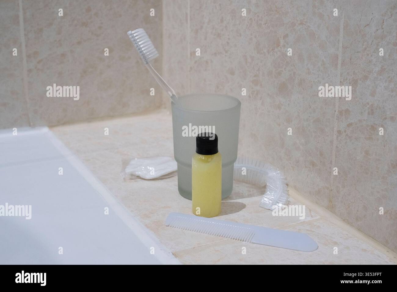 Articoli da toeletta dell'hotel con spazzolino da denti, shampoo e cuffia per doccia. Foto Stock
