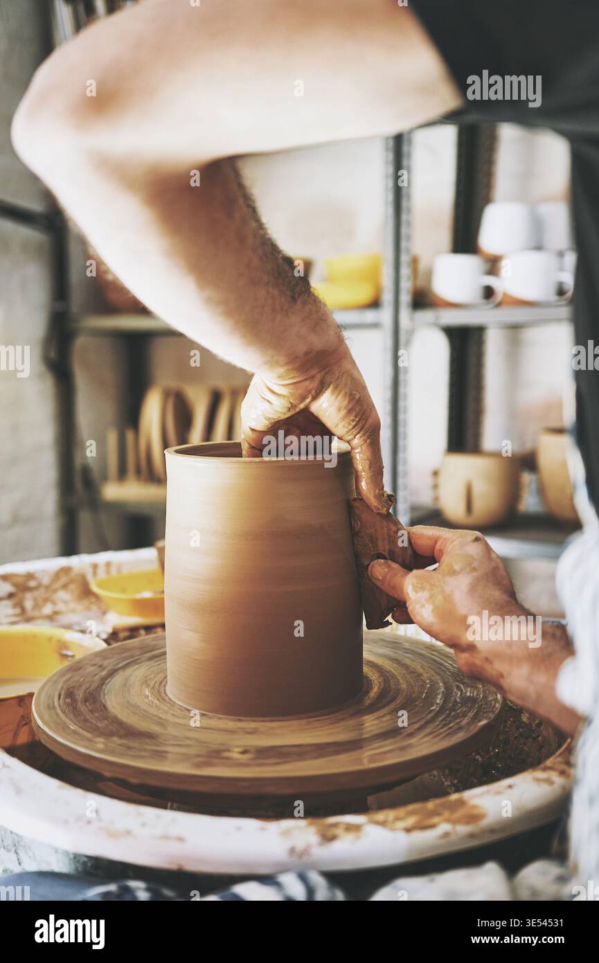 Creatività, mani e strumenti con la persona in un laboratorio di ceramica per la produzione o la produzione di ceramiche. Argilla, processi e piccole imprese con artigiani in Foto Stock
