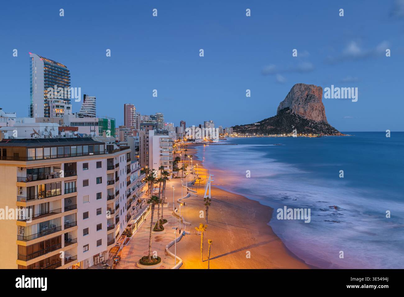 Una tranquilla foto serale di Calpe scattata dopo il tramonto durante il crepuscolo, vista da una posizione leggermente elevata lungo la spiaggia towar Foto Stock