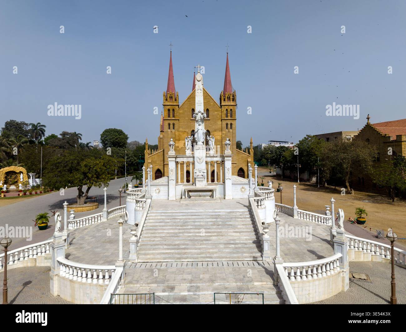 Vista aerea della cattedrale di San Patrizio con guglie rosse e il monumento in marmo bianco al Cristo Re a Karachi, Sindh, Pakistan. Foto Stock