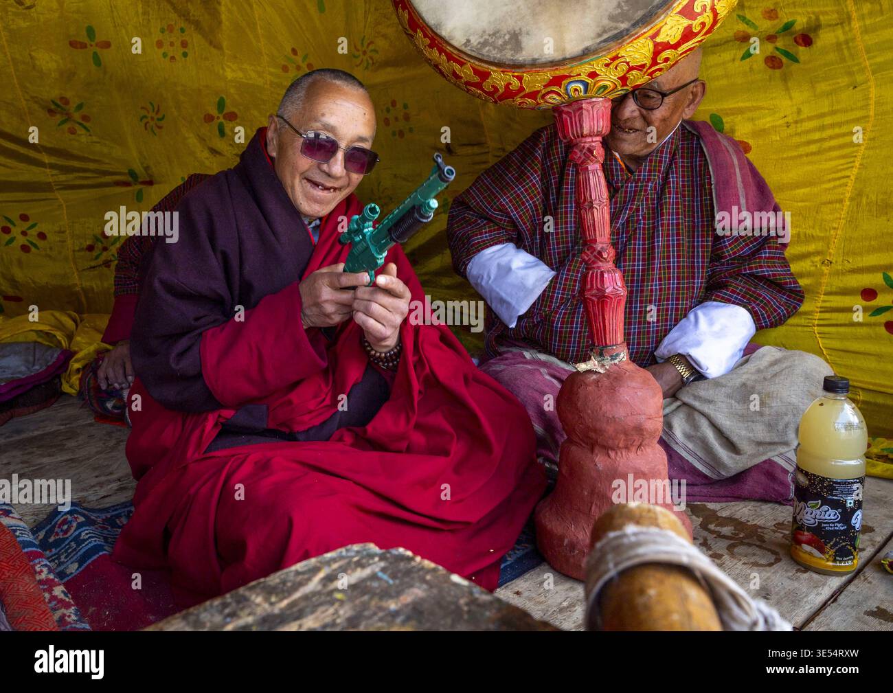 Bhutan, Bumthang, Ura, monaco con un giocattolo a pistola nel monastero di Ura Lhakhang durante il festival Foto Stock