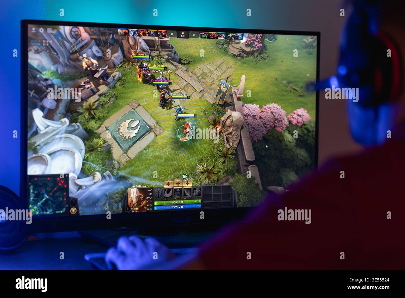 Gamer che gioca a Dota 2 su un monitor del computer, mostrando un'azione di gioco MOBA strategica con un'interfaccia per personaggi e mappe, eSport e giochi online competitivi Foto Stock
