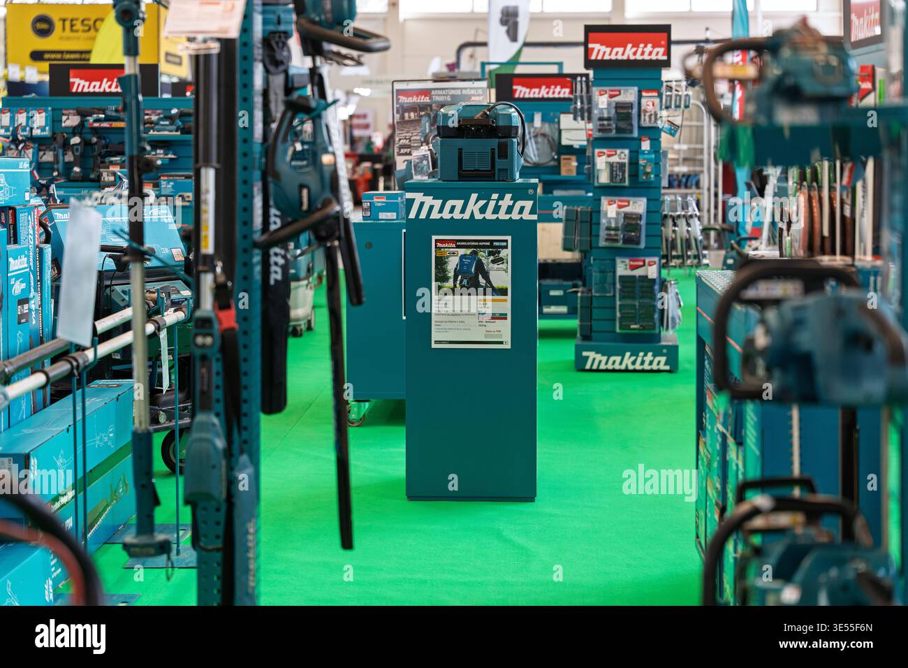 Utensili elettrici professionali e attrezzature da giardino Makita esposti a una fiera commerciale al chiuso, con un'ampia gamma di batterie cordless Foto Stock