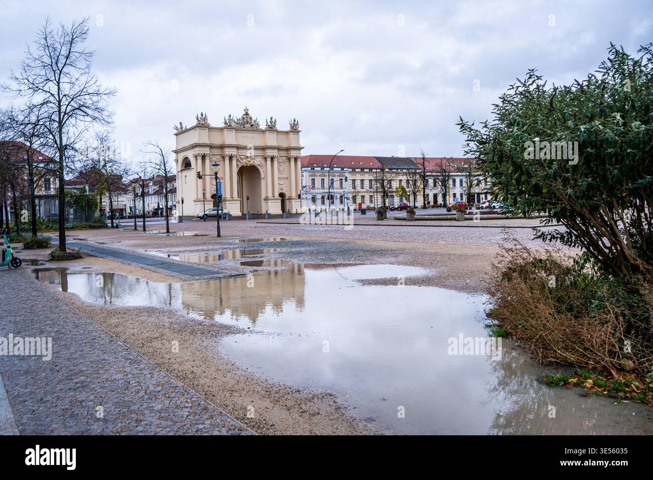 Pozzanghere dopo la pioggia vicino alla porta di Brandeburgo a Potsdam, Germania. Edificio architettonico di strada. Piazza del centro storico Potsdam, Germania - 26 ottobre 2025. Foto Stock
