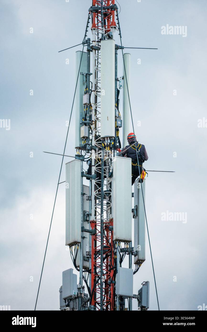 Interventi di manutenzione sulla torre radio della rete di telefonia mobile Foto Stock