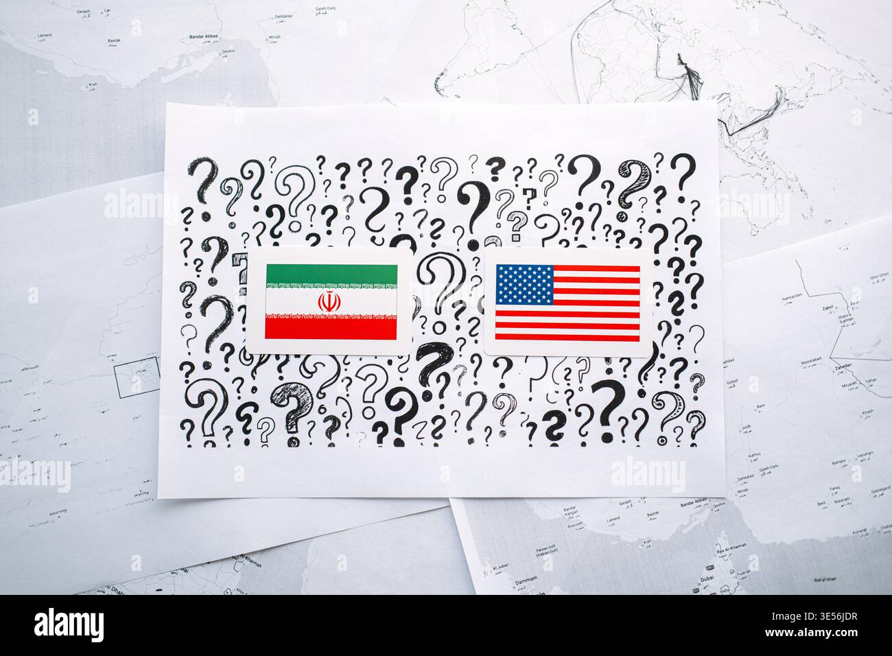 Le carte con bandiere dell'Iran e degli Stati Uniti si trovano su carta con punti interrogativi sulle mappe geografiche. Relazioni USA con l'Iran, risoluzione dei conflitti, accordo nucleare Foto Stock