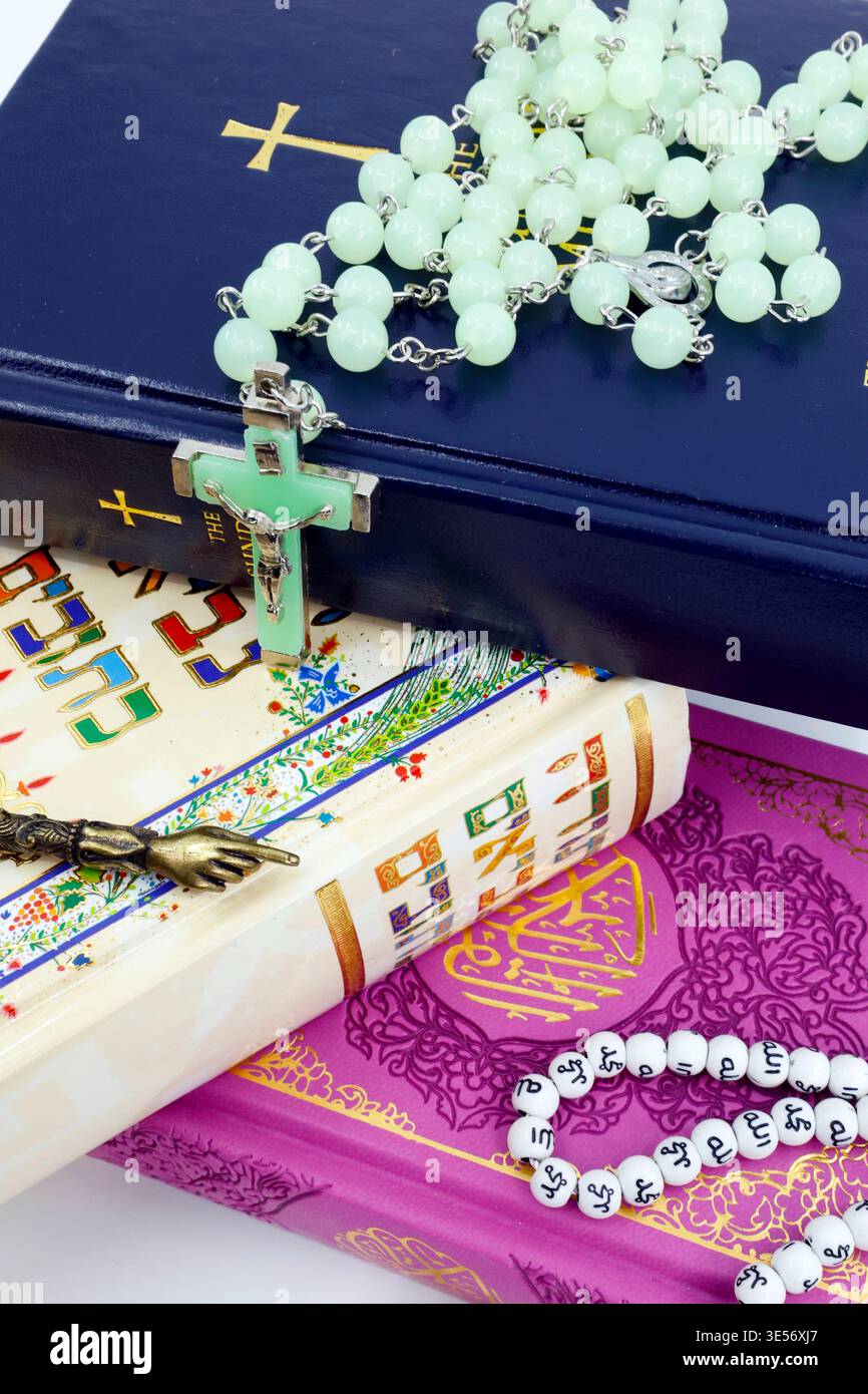 Un potente simbolo di unità interreligiosa: Il messale cristiano, la Torah ebraica e il Corano islamico impilati con un rosario, un puntatore yad e la preghiera misbaha Be Foto Stock