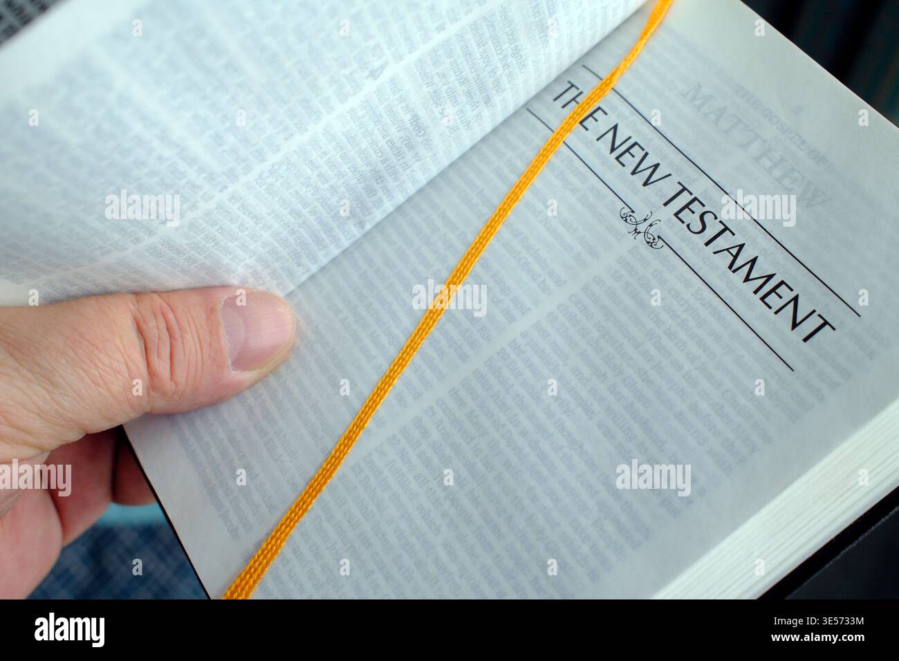 Apri la Bibbia tenuta in mano e mostra il frontespizio del nuovo Testamento con il nastro giallo. Foto Stock