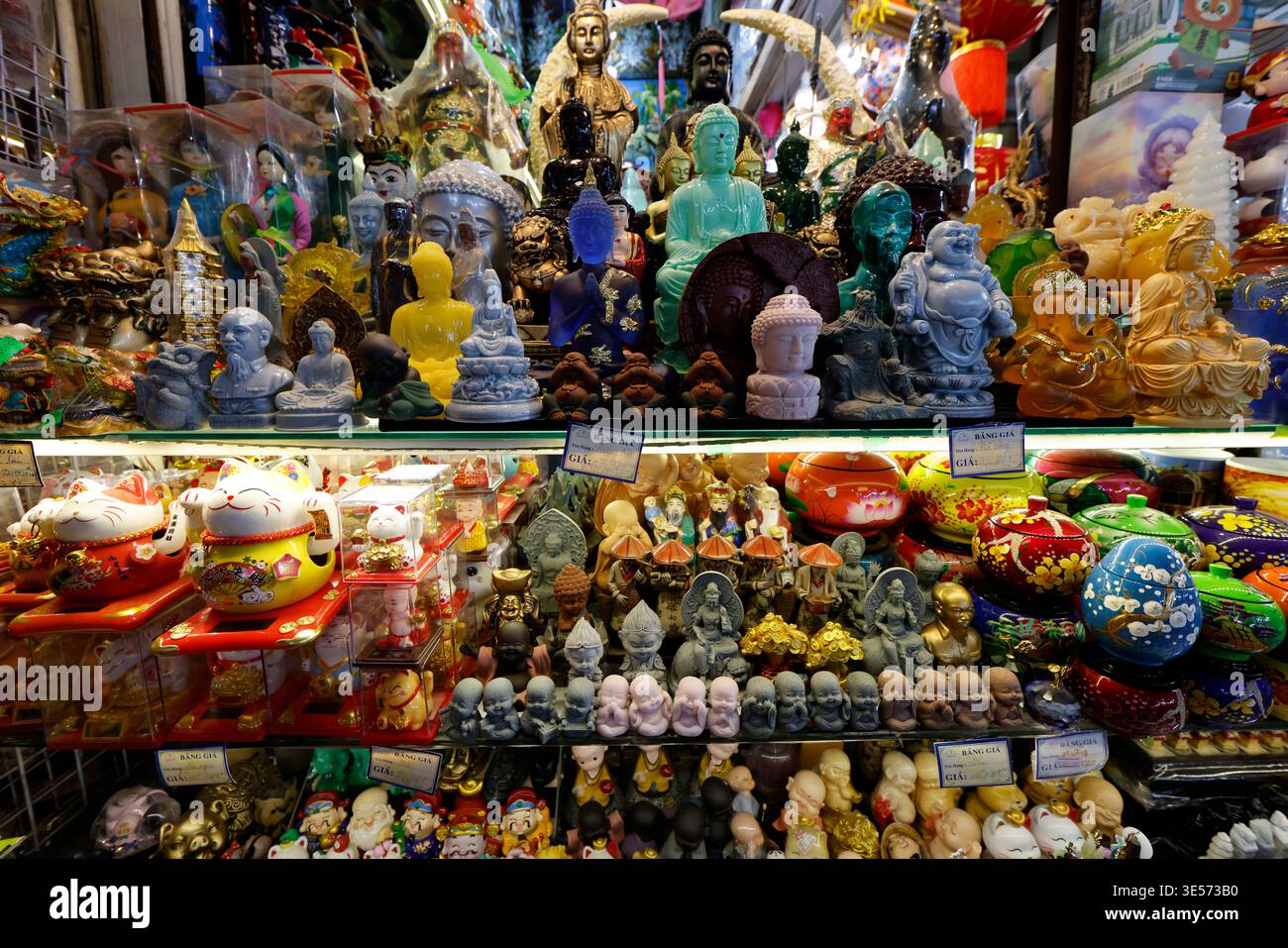 Affollato mercato vietnamita con statue colorate di Buddha, gatti fortunati e statuette religiose. Ho chi Minh. Vietnam. Foto Stock