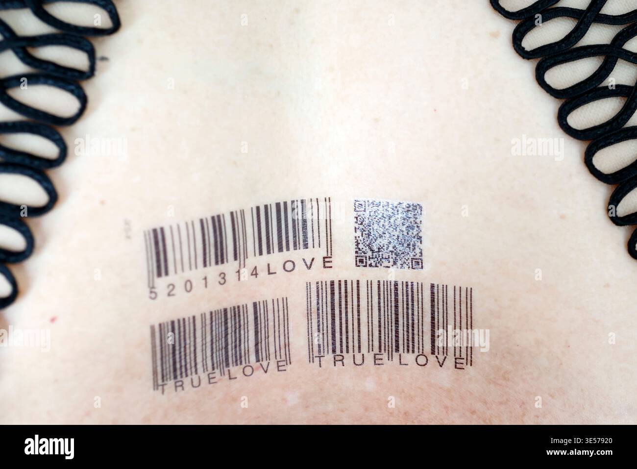 Primo piano di tatuaggi temporanei con codice a barre che scrivono TRUE LOVE 20134 sulla pelle pallida. Cattura una fusione ironica di tecnologia dei codici a barre e tema d'amore eterno. Sopot. P Foto Stock